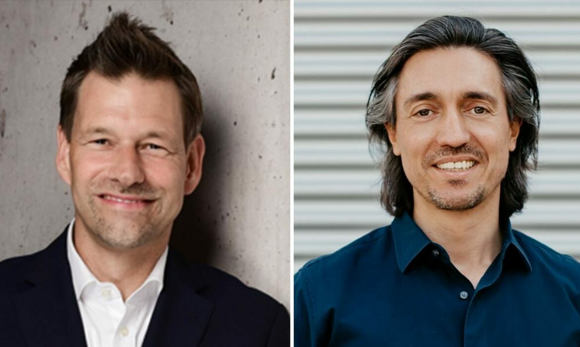 Zweigeteiltes Bild mit zwei Männern. Links: Mann mit kurzen braunen Haaren, hellem Teint, im dunklen Anzug und weißem Hemd, lächelt freundlich, neutraler Hintergrund mit Betonoptik. Rechts: Mann mit mittellangen dunklen Haaren, etwas dunklerem Teint, in dunkelblauem Hemd, ebenfalls lächelnd, Hintergrund aus waagerechten grauen Metalllamellen. Beide Männer blicken direkt in die Kamera.