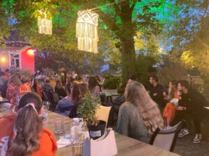 Mitarbeiter der intan group bei einem Sommerabend auf dem Heger Tor. Die Atmosphäre wird bestimmt durch beleuchtete Bäume und Leuchtmittel.